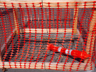 Red plastic mesh around some ground works in a path