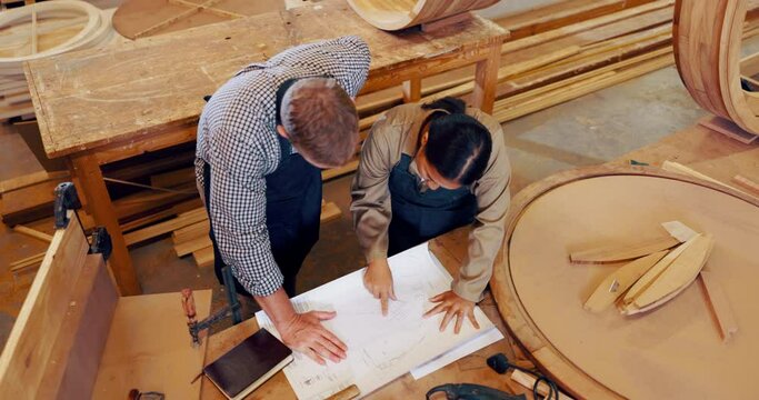 Man, woman and woodworking in workshop with paper for handmade furniture, manufacturing or production. Teamwork, construction and small business contractor for building craft, lumber or carpentry