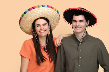 Lovely couple woman in Mexican sombrero hats on beige background