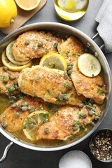 Delicious chicken piccata on grey table, flat lay