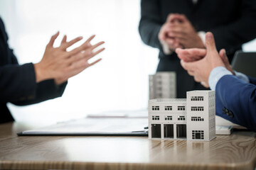 Two individuals shake hands in agreement after a successful business meeting with a condominium...
