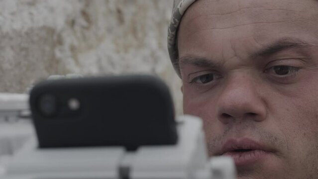 Closeup on man's face looking at phone on toy laser gun