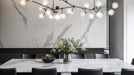 The dining room features a simple yet stylish design with a white marble dining table and black leather chairs. As a bold addition an oxidized metal chandelier hangs above the table .