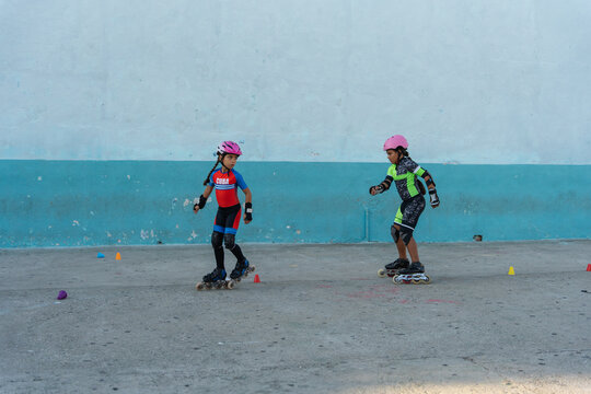 Little Girls Doing Roller Skating Outdoors.
