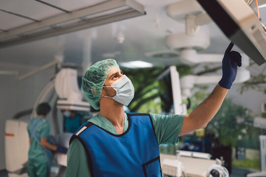 Surgeon looking at scans on monitor screen