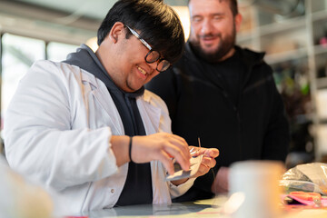 Happy diverse men colleagues standing at table of leather workshop