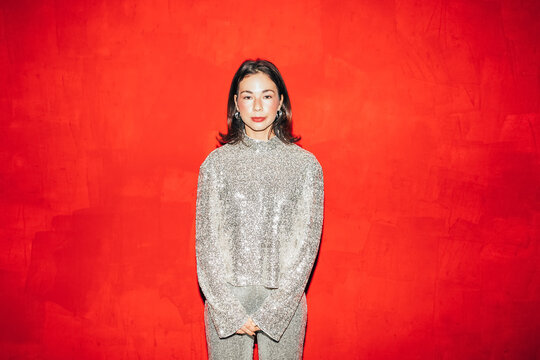 Woman posing in front of red wall