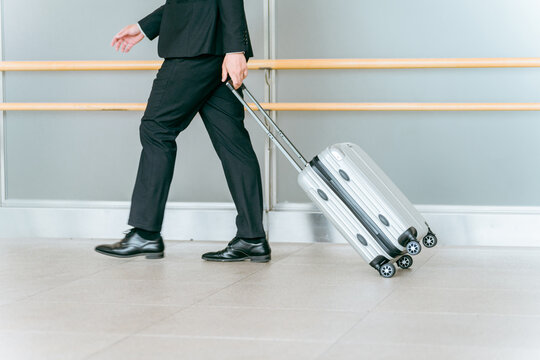 スーツケース・キャリーケースを持って出張に行くビジネスマン・海外出張・海外赴任・商社・貿易
