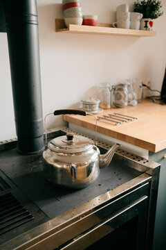 kettle on stove in modern farmhouse kitchen with wood stove