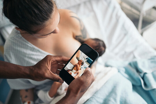 taking picture of newborn baby breastfeeding