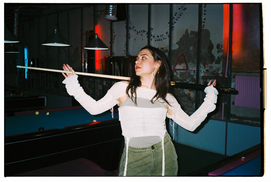 Young woman posing with a cue 