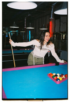 young woman plays billiard