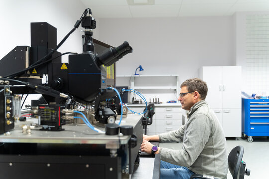 Scientist Working With Electronic Microscope