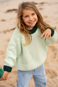 A blonde girl laughing at the beach