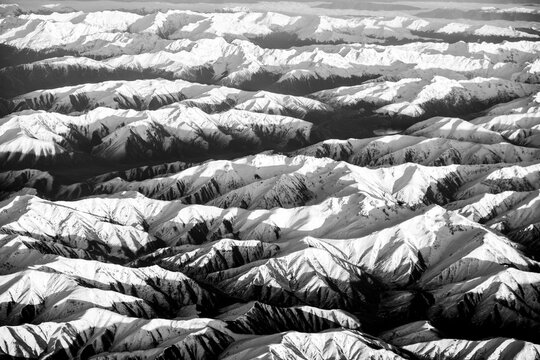 Aerial view of snowcapped mountains in black and white
