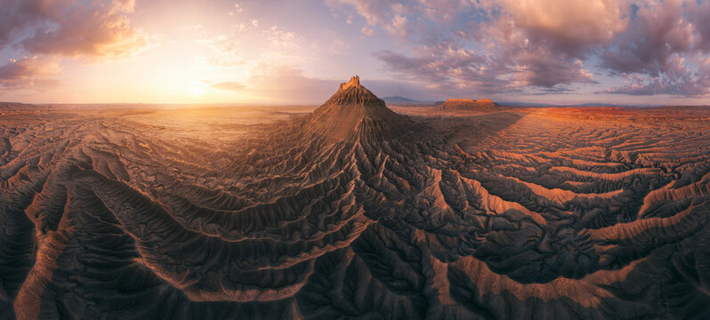 Big mountain surrounded by badlands in desert