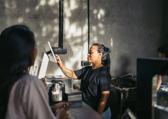 Waitress processing payments in a modern cafe