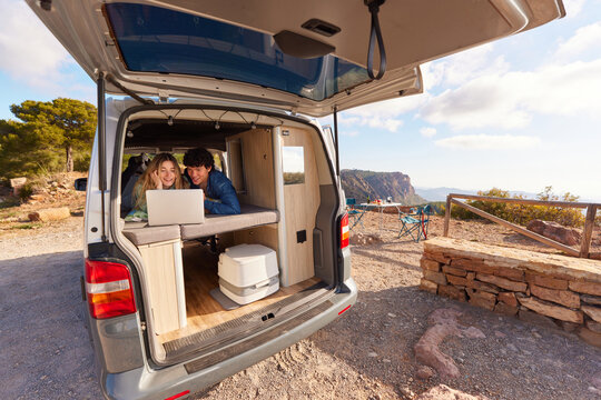 Young couple watching film in camper