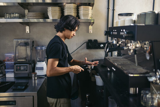 Young man making coffee in a coffee shop in Bali