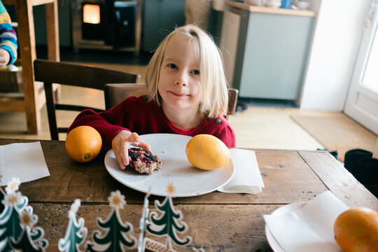 portrait of little blonde girl having holiday breakfast 