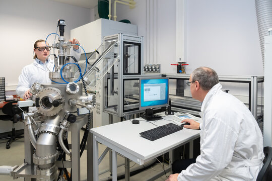 People Working With Pulsed Laser Deposition System In The Lab