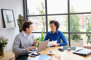 Cheerful multiracial coworkers collaborating on project