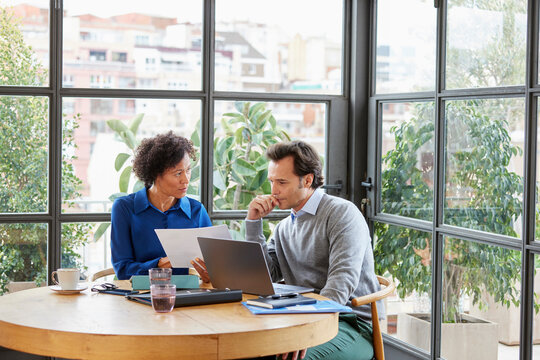 Black female manager showing document to boss