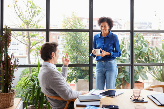 Cheerful diverse colleagues having coffee break