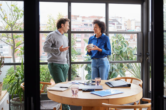 Diverse coworkers chatting during break at work