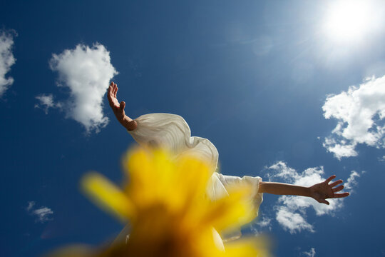 A girl in white dancing in the blue sky 