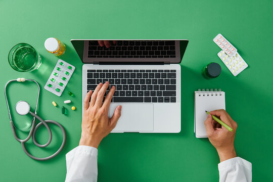 Doctor write medical records on a notepad with a computer