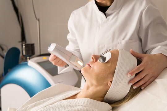 Young woman getting laser procedure on a face 