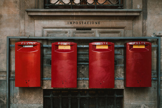 Red post boxes on the wall of post office in Italy