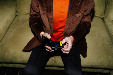 Crop man loading film into camera