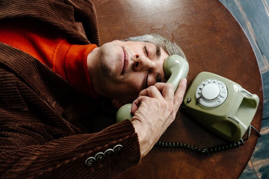 Tired businessman with retro rotary phone