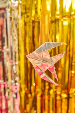 Origami silver fish on tinsel background