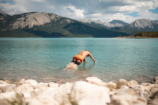 boy dives into blue lake
