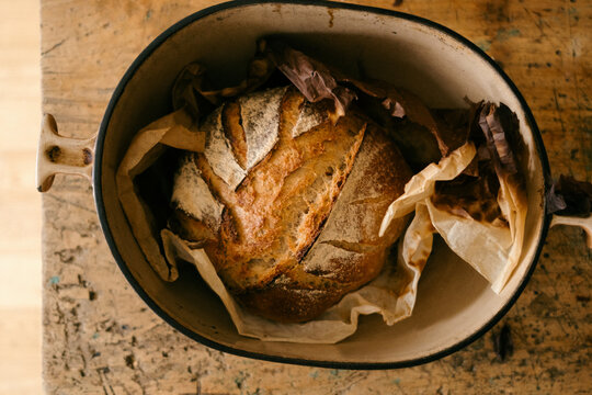 fresh baked sourdough loaf in cast iron pan 