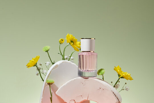 still life with pink perfume bottle and daisy flowers