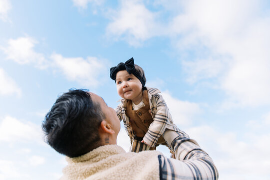 mother throwing smiling daughter up into the air