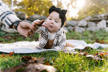 happy little baby outdoors in autumn on a blanket