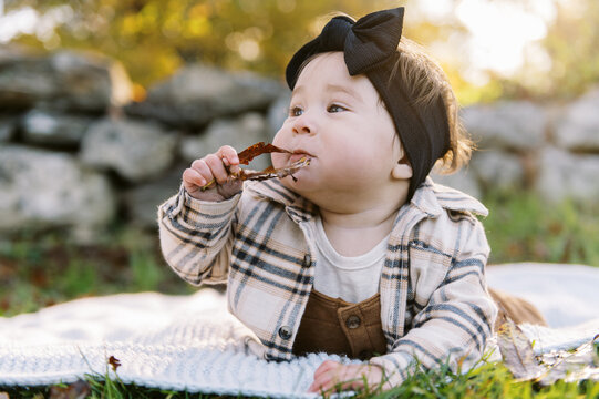 happy little baby outdoors in autumn on a blanket