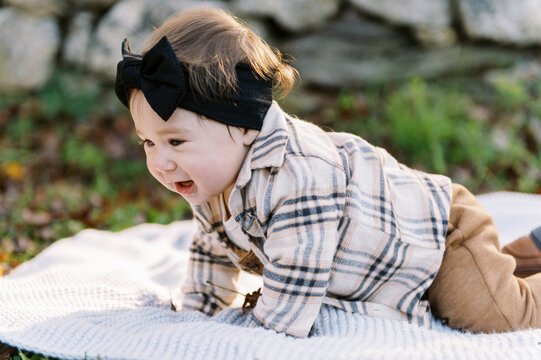 happy little baby outdoors in autumn on a blanket