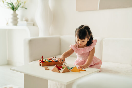 A little girl building castle using cubes