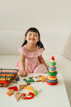 Little asian baby girl playing with toy blocks at home