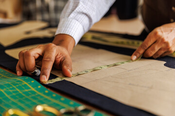Cropped image of tailor measuring garment on table