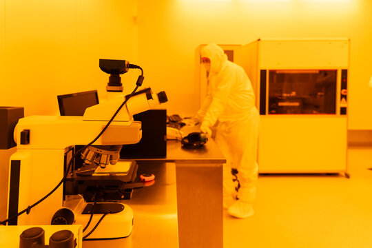Researcher Working In Yellow Light Clean Room 