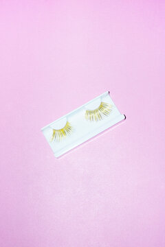 Golden shiny metallic lashes/lash extensions on a colour background