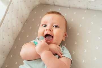 Funny infant lying in crib with pacifier