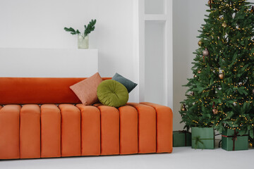 Armless sofa with round back near decorated Christmas tree at home